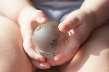 Glass globe, planet Earth, in the hands of a child.