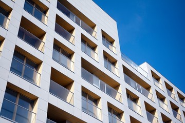 Exterior of new apartment buildings on a blue cloudy sky background. No people. Real estate business concept.