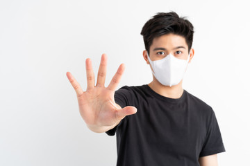 Stop Civid-19 , Asian man wearing Face Mask show stop hands gesture for stop corona virus outbreak , protect spread Covid-19 Coronavirus concept
