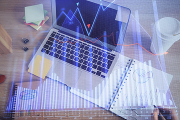 Double exposure of man's hands writing notes of stock market with forex chart.