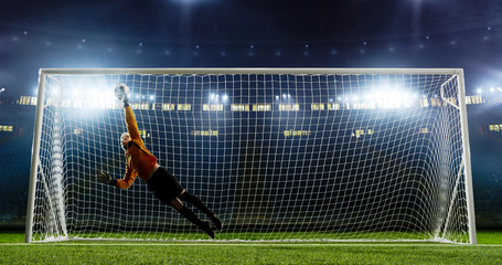 Goalkeeper is trying to save from a goal on an empty soccer stadium. No spectators on the tribunes....