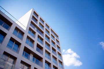 Exterior of new apartment buildings on a blue cloudy sky background. No people. Real estate business concept.