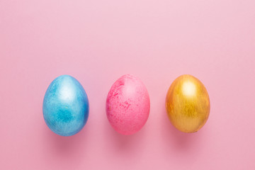 Multi-colored Easter eggs on a pink isolated background. Easter is a bright holiday.