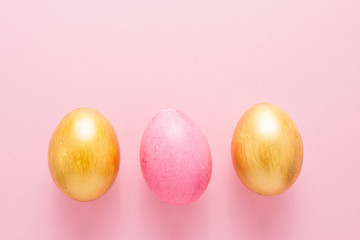 Multi-colored Easter eggs on a pink isolated background. Easter is a bright holiday.