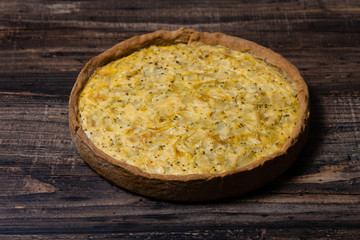 Kish with caramelized onions, dill and cream cheese on a Wooden Table