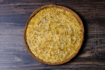 Kish with caramelized onions, dill and cream cheese on a Wooden Table