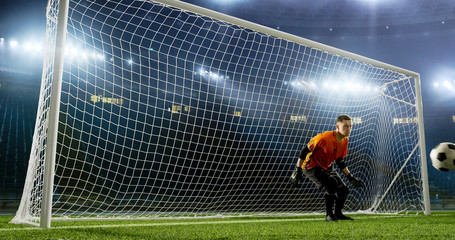 Goalkeeper is trying to save from a goal on an empty soccer stadium. No spectators on the tribunes. Stadium is made in 3d.