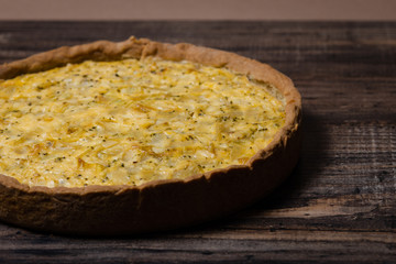 Kish with caramelized onions, dill and cream cheese on a Wooden Table