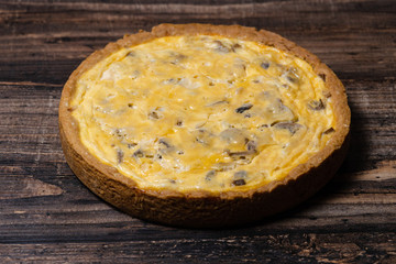 Appetizing kish with chicken and mushrooms on a Wooden Table