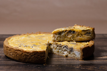 Appetizing kish with chicken and mushrooms on a Wooden Table