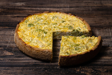 Appetizing kish with broccoli and cheese on on a Wooden Table