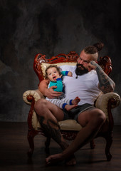 Fototapeta na wymiar sporty brutal man holds in arms a little baby