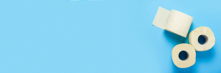 toilet paper rolls on a blue background. Flat lay, top view. Baner. Hygiene concept, deficiency, quarantine. Banner.