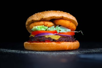Tasty cheeseburger with onion rings