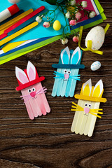 Easter bunny toy gift stics puppets on wooden table. Handmade. Project of children's creativity,...