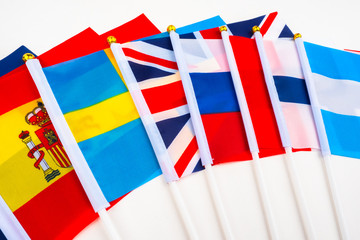 Flags of different countries are on the white table. Symbols of States. Political and economic...