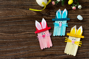 Easter bunny toy gift stics puppets on wooden table. Copy space. Handmade. Project of children's...