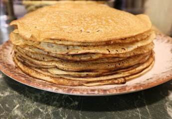 Texture of pancakes lying in a pile on the table.