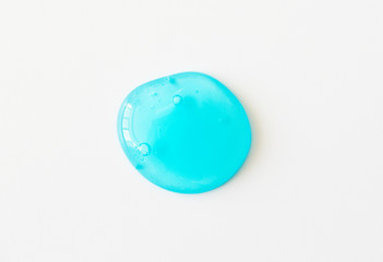 Blue shower gel or fresh transparent toothpaste spot with air bubbles on white background. Cosmetic...