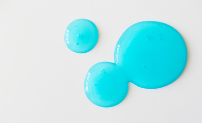 Antiseptic and antibacterial hand sanitizer on white background, above. Blue transparent gel smudge