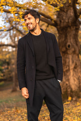 Lifestyle, a young businessman in a black suit in a natural park