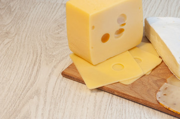 Piece of cheese on a wooden board. Top view