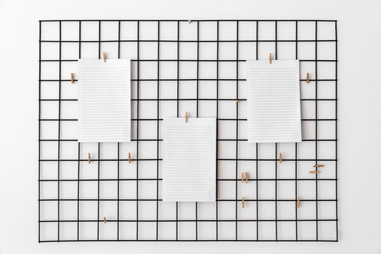 Blank paper attached with pegs on grid as notice, reminder or planing board for succesfully following tasks or goals.