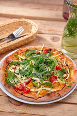 pizza with fresh vegetables on the wooden background