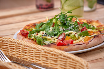 pizza with fresh vegetables on the wooden background