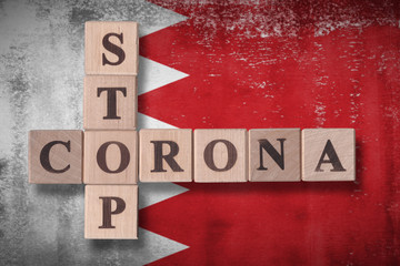 Flag of Bahrain with wooden cubes spelling STOP CORONA on it. 2019 - 2020 Novel Coronavirus (2019-nCoV) concept art, for an outbreak occurs in Bahrain.