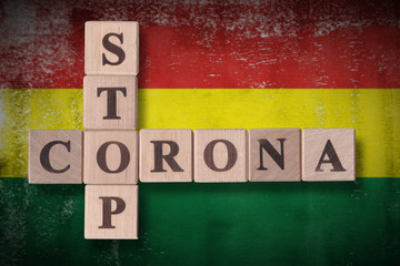 Obraz premium Flag of Bolivia with wooden cubes spelling STOP CORONA on it. 2019 - 2020 Novel Coronavirus (2019-nCoV) concept art, for an outbreak occurs in Bolivia.
