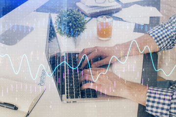 Multi exposure of graph with man typing on computer in office on background. Concept of hard work. Closeup.