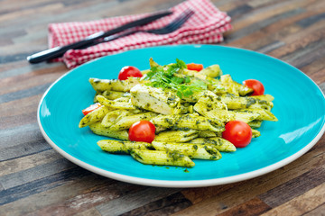 close-up of plate of pasta and chicken with lettuce