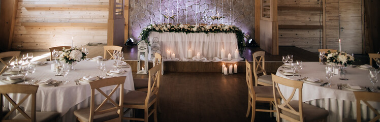 Wonderful decoration of the wedding restaurant and tables with plates  and candles