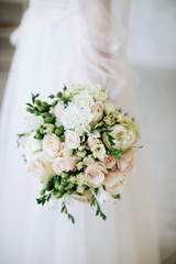 Wedding flowers.  The bride holds a beautiful wedding bouquet of roses