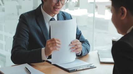 Senior manager reading a resume during a job interview employee young man meeting Applicant and recruitment concept