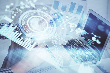 Double exposure of businessman working on laptop on background. International business hologram in front. Concept of success.