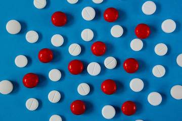 many white and red pills on a blue background