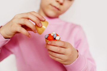 The girl is holding small chocolate eggs lying in one large egg. Concept of the Easter holiday