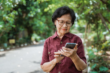 old woman enjoy using a smartphone for watching a video