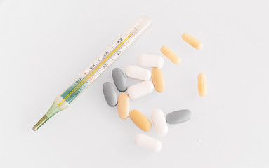  thermometer and pills isolated. treatment of the disease