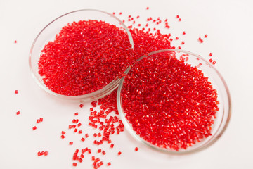 Red, plastic granules of polycarbonate isolated on white background