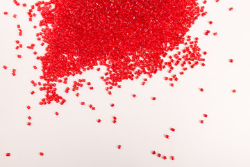 Red, plastic granules of polycarbonate isolated on white background