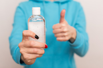 Girl using alcohol antiseptic gel, holds in hands sanitizer to avoid contaminating with virus...