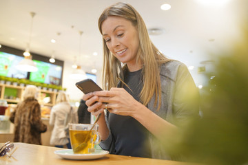 portrait of a young woman on the phone in a cafe