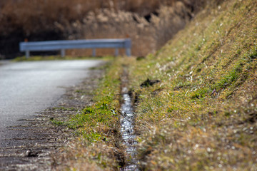 春先の田舎道の排水溝 a gutter 