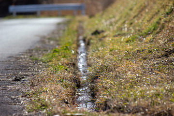春先の田舎道の排水溝 a gutter 