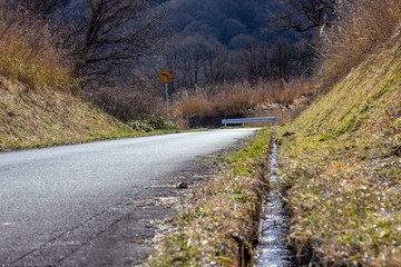 春先の田舎道の排水溝 a gutter 