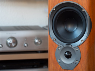 A close-up of the hi-fi speaker with blurred hi-fi equipment in background.