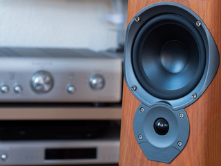 A close-up of the hi-fi speaker with blurred hi-fi equipment in background.